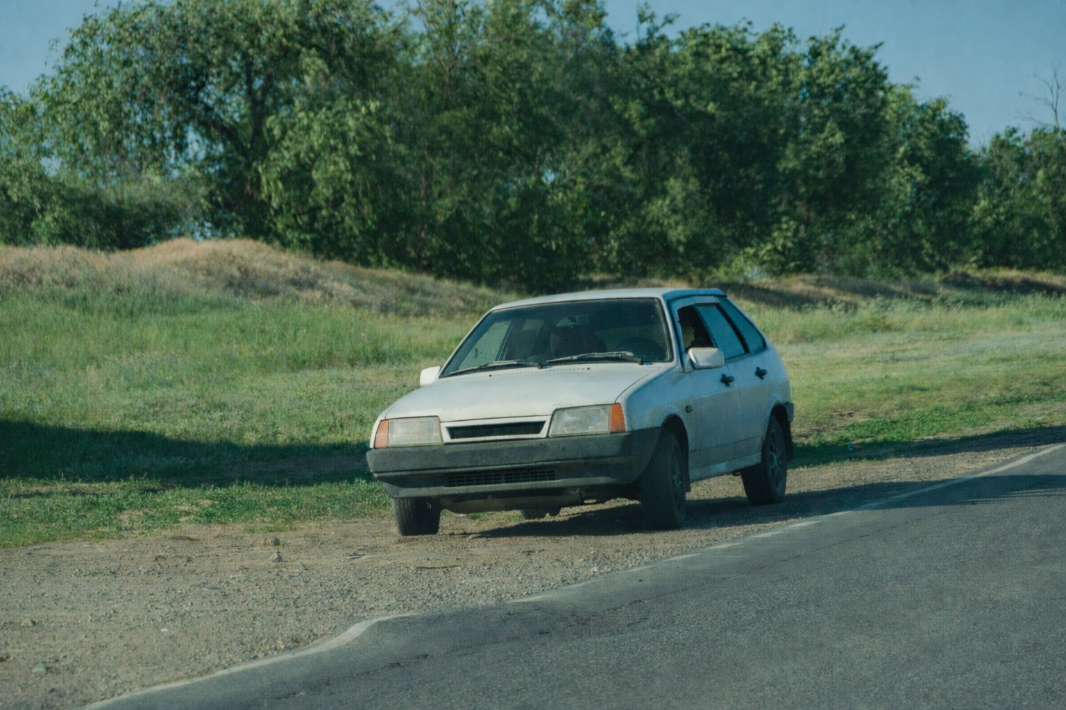 Car positioned safely with hazard lights activated on firm, level pavement