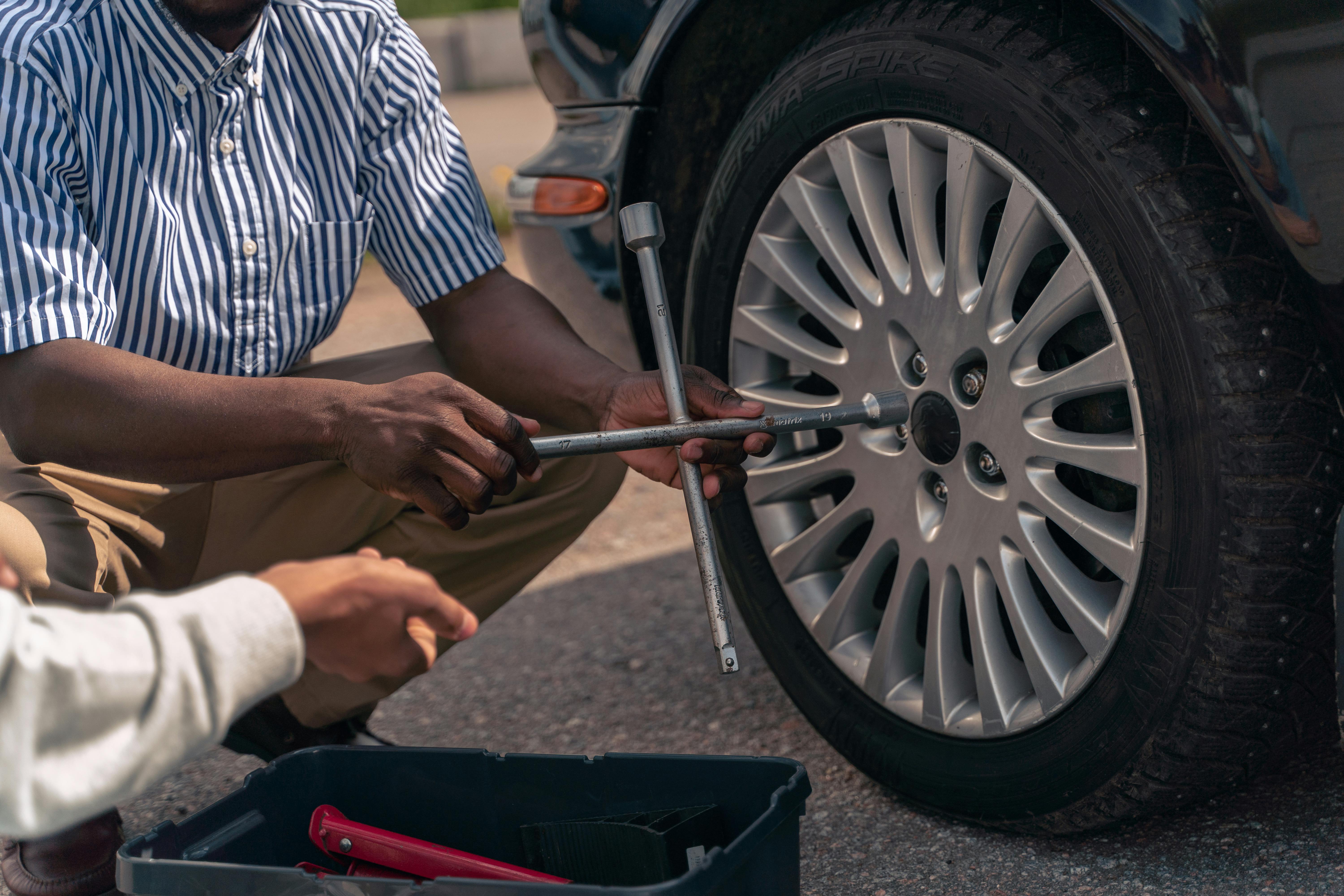 Wrench applying torque to fasteners with the wheel partially supporting vehicle weight
